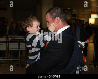 Der Engländer Andrew Strauss kuschelt seinen Sohn Luca, als er am Londoner Flughafen Heathrow ankommt. Stockfoto
