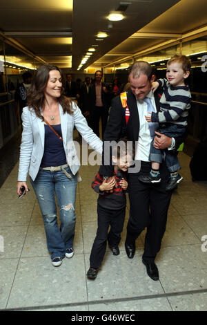 Cricket - Ankunft Des England-Teams - Flughafen Heathrow. Der Engländer Andrew Strauss wird von seiner Frau Ruth und den Söhnen Luca (getragen) und Sam bei seiner Ankunft am Londoner Flughafen Heathrow empfangen. Stockfoto