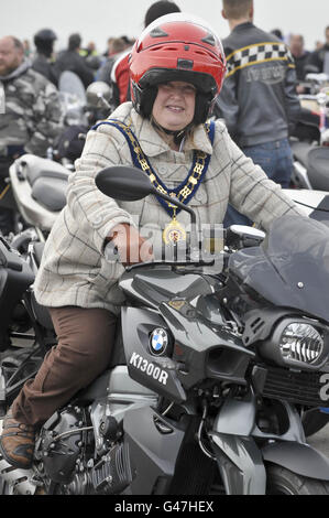 Die Bürgermeisterin von Wootton Bassett, Mary Champion sitzt in der Fahrerposition auf einem Motorrad, wo sie Pillion durch ihre Stadt reiten wird, Als Motorradfahrer versammeln sich auf dem Flugplatz Hullavington in Vorbereitung auf die "Ride for Respect" Charity-Fahrt durch die Wiltshire-Stadt Wootton Bassett zu Hilfe von Afghan Heroes. Stockfoto