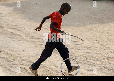 Kenia Turkana-Region, UNHCR Flüchtlingslager Kakuma, wo dauerhafte 80,000 Flüchtlinge aus Somalia, Äthiopien, Süd-Sudan leben, Somali junge spielt mit Rand Stockfoto