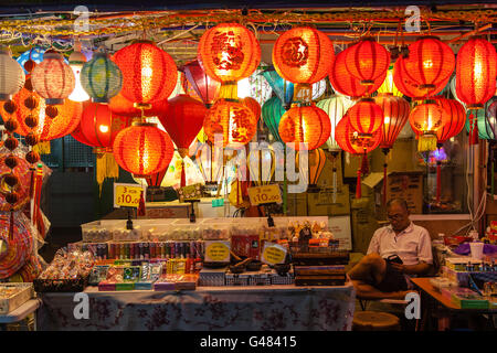 Singapur, Singapur - 12. Dezember 2014: Eine Straße Verkäufer in Chinatown wacht über sein Geschäft mit Lampions. Stockfoto