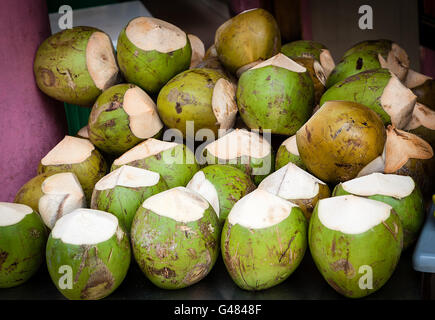 Haufen Kokosnüsse mit der Spitze geschnitten auf einem Straßenmarkt zum Verkauf bereit. Kokosnuss Getränke sind super feuchtigkeitsspendende. Sie sind arm an calori Stockfoto