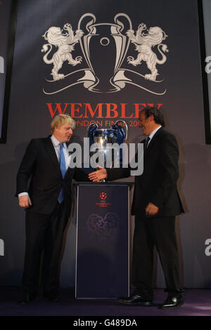 UEFA-Präsident Michel Platini schüttelt die Hand des Londoner Bürgermeisters Boris Johnson, nachdem er bei der UEFA Champions League Trophy in der Guildhall in London für die Medien posiert hat. Stockfoto