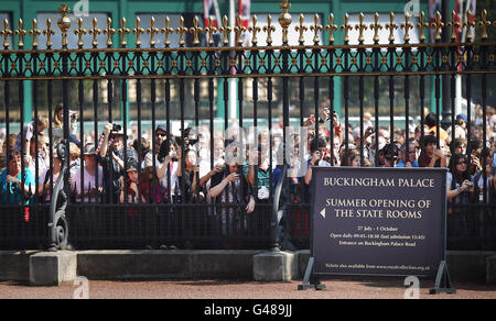 Die Zuschauer beobachten die Wachablösung durch das Geländer des Buckingham Palace in London. Stockfoto