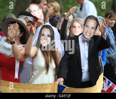 Mitglieder der Öffentlichkeit tragen Masken von Prinz William und Kate Middleton, während sie auf der Mall vor der königlichen Hochzeit von Prinz William und Kate Middleton warten. Stockfoto