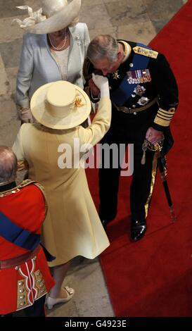 Prinz Charles (rechts) küsst die Hand seiner Mutter, Königin Elizabeth II (Mitte), neben seiner Frau, der Herzogin von Cornwall, als sie in Westminster Abbey vor der Hochzeit von Prinz William und Kate Middleton im Zentrum von London ankommen. Stockfoto