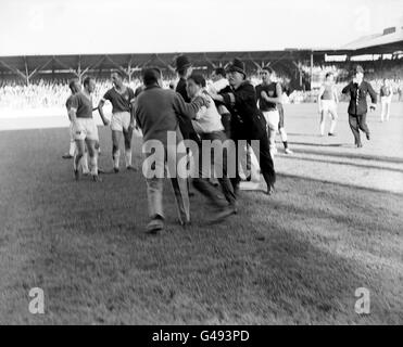 Die Polizei zieht ein, um Zuschauer zu entfernen, die auf das Spielfeld gelaufen waren und den Schiedsrichter Leslie Hamer nach einem Vorfall attackierten, bei dem West Ham United Torhüter Lawrence Leslie auf einer Bahre abtransportiert wurde. Stockfoto