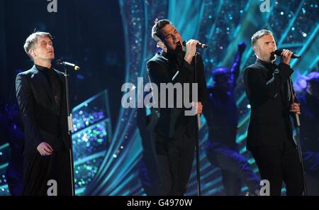 (Von links nach rechts) Mark Owen, Robbie Williams und Gary Barlow nehmen das während der National Movie Awards 2011 in der Wembley Arena, London, auf die Bühne Stockfoto