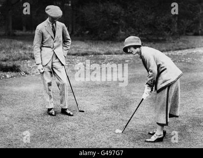 Die Herzogin von York (später die Königin-Mutter) und ihr Mann, der Herzog von York (später König George VI) genießen während ihrer Flitterwochen eine Partie Golf im Polesden Lacey in Surrey. Stockfoto