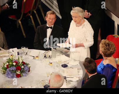 Die britische Königin Elizabeth II. Lächelt nach ihrer Rede im Dublin Castle, beobachtet von einem Taoiseach Enda Kenny (links sitzend) und der irischen Präsidentin Mary McAleese (rechts) während eines Staatsdinners am zweiten Tag ihres Staatsbesuchs in Irland. Stockfoto