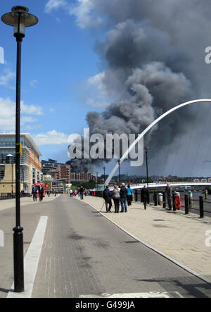 Rauch steigt aus der Szene eines Feuers auf einem ehemaligen Schrottplatz in Byker, Newcastle. Stockfoto