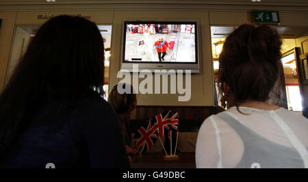 Die Menschen beobachten die königliche Hochzeit von Prinz William und Kate Middleton auf einem Bildschirm in Marple, Cheshire. Stockfoto