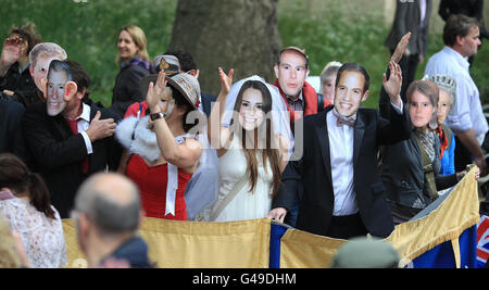 Mitglieder der Öffentlichkeit tragen Kate Middleton und Prince William Masken in der Mall, nachdem sie in der Westminster Abbey im Zentrum von London geheiratet haben. Stockfoto