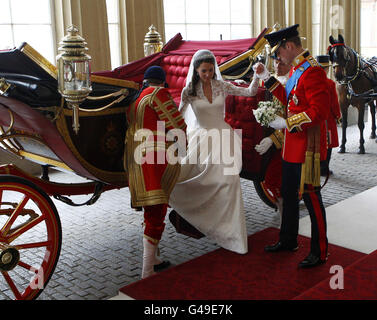 Der britische Prinz William (rechts) hilft seiner Braut Kate, den 1902 State Landau zu verlassen, als sie nach ihrer Hochzeit im Buckingham Palace im Zentrum Londons ankommt. Stockfoto