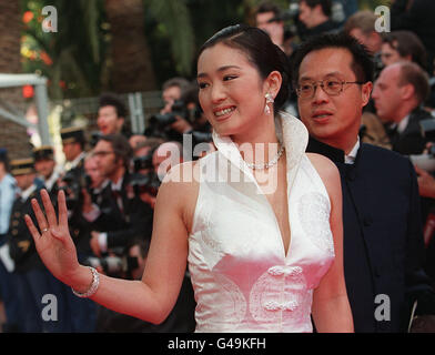 Chinesische Schauspielerin Gong Li winkt der Masse als sie am Palais des Festivals 07. Mai zur Eröffnungsfeier des 50. Cannes Filmfestival ankommt. Der Film "Das fünfte Element" unter der Regie von Luc Besson und starring Bruce Willis ist aus dem Wettbewerb am Eröffnungsabend vorgestellt. (Mann an R ist unbekannt) Stockfoto