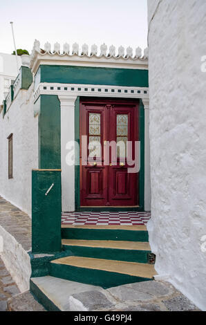 Rote Tür auf einer weißen und grünen Wand, in der Hydra-Insel, Griechenland Stockfoto