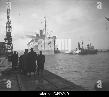 Der riesige Cunard-White Star-Liner RMS Queen Mary schafft es schließlich in Southampton ins Dock zu legen, nachdem sie aufgrund einiger der schwersten atlantischen Stürme im menschlichen Gedächtnis schwer behindert wurde. Stockfoto