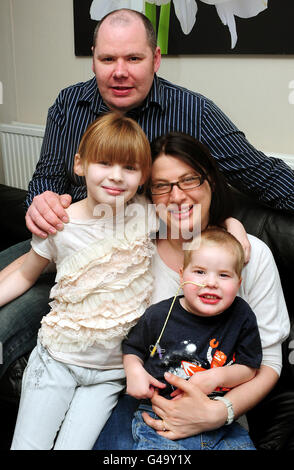 Mason Lewis mit Mutter Rebecca, Vater Steven und Schwester Indiana zu Hause in Atherstone, Warwickshire. Der vierjährige Junge ist zur kleinsten Person in Großbritannien geworden, die eine erfolgreiche Lungentransplantation hat. Stockfoto