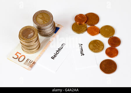 Zeichen "Reichtum" und "Armut", Deutsch für "Wohlstand" und "Armut", "gestapelt Euro-Münzen in Euro-Banknoten Stockfoto