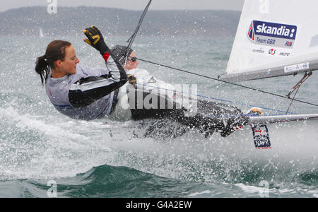 Mitglieder des britischen olympischen Segelteams der Klasse 470, Penny Clark (hinten) und Kat Hughes, an der Weymouth and Portland National Sailing Academy, dem Veranstaltungsort der Olympischen Spiele 2012 in London. Stockfoto