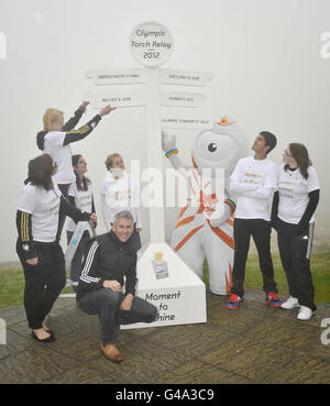 Der Olympiasieger Jonathan Edwards trifft sich mit jungen Goldbotschaftern aus ganz Großbritannien und lokalen Schulkindern aus Cornwall am Schild „Mock-up“ in Lands End, Cornwall, um die offizielle Ankündigung der olympischen Fackellauf-Route quer durch Großbritannien zu markieren. Stockfoto