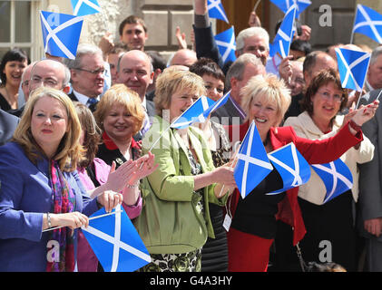 Die MSPs winken, als Alex Salmond, Vorsitzender der schottischen Nationalpartei, abreist, nachdem er als erster Minister im schottischen parlament in Edinburgh gewählt wurde. Stockfoto