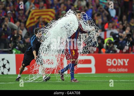 Gerard Pique aus Barcelona feiert den Sieg, indem er nach dem letzten Pfiff ein Souvenir in Form eines der Tornetze nimmt Stockfoto