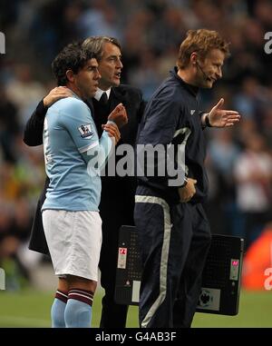 Fußball - Barclays Premier League - Manchester City / Tottenham Hotspur - City of Manchester Stadium. Roberto Mancini, Stadtmanager von Manchester, gibt Carlos Tevez Anweisungen, bevor er sich einlässt Stockfoto