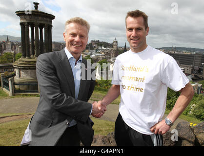 Der schottische Rugby-Spieler Chris Pherson (rechts) und LOCOG-Chef Paul Deighton helfen beim Start der schottischen Etappe der Olympischen Fackellauf in London 2012 auf Calton Hill in Edinburgh, Schottland. Stockfoto