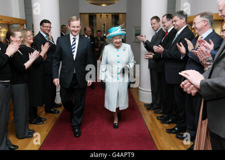 Königin Elizabeth II. Trifft den irischen Premierminister Enda Kenny spazieren am zweiten Tag ihres Staatsbesuches in Irland an applaudierenden Mitarbeitern in Regierungsgebäuden vorbei. Stockfoto