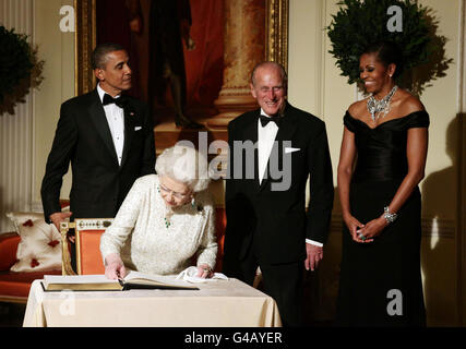 Königin Elizabeth II. Unterschreibt das Gästebuch, während sie sich von US-Präsident Barack Obama und First Lady Michelle Obama verabschiedet, während sie vom Herzog von Edinburgh im Winfield House - der Residenz des Botschafters der Vereinigten Staaten von Amerika - im Regent's Park, London, beobachtet wird. Stockfoto