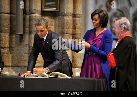 US-Präsident Barack Obama, der von seiner Frau, First Lady Michelle Obama, beobachtet wird, signiert das berühmte Besucherbuch während einer Tour durch Westminster Abbey im Zentrum von London im Rahmen seines dreitägigen Staatsbesuchs in Großbritannien. Stockfoto