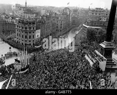 Eine solide Masse von Menschen auf dem Trafalgar Square, wie der State Coach, gezogen von acht grauen Pferden, mit Queen Elizabeth II und dem Herzog von Edinburgh an der regengefegten Cockspur Street in der Prozession von Westminster Abbey zum Buckingham Palace vorbeifährt. Stockfoto