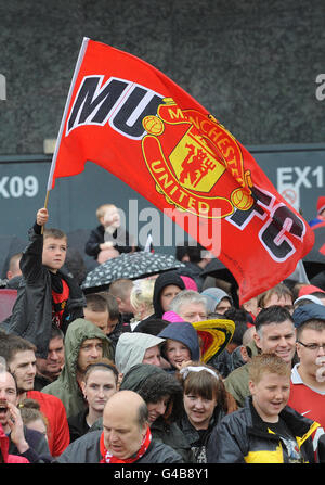 Manchester United-Fans sehen zu, wie ihr Team den Sieg in der Premier League mit einer offenen Busparade vor Old Trafford, Manchester feiert. Stockfoto