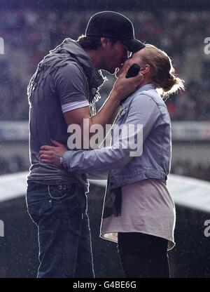 Enrique Iglesias küsst Sophie Elphick, 18, auf der Bühne während des Capital FM's Summertime Ball im Wembley Stadium, London. Stockfoto