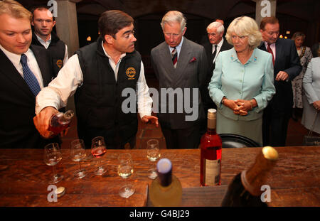 Der Prinz von Wales und die Herzogin von Cornwall probieren Wein mit dem Weinhersteller Andrew Reed (2. Links) während eines Besuches im Denbies Wine Estate in Dorking, Surrey, während sie eine Reihe von Engagements im gesamten Land Unternehmen. Stockfoto