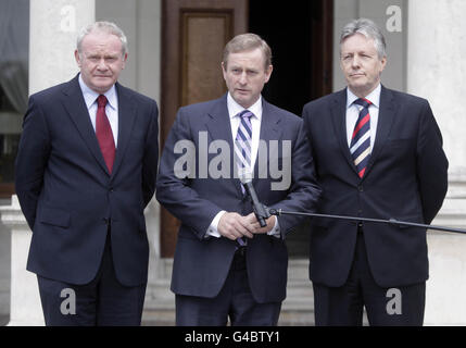 Taoiseach Enda Kenny wird von dem stellvertretenden Premierminister von Nordirland, Martin McGuiness (links), und dem ersten Minister von Nordirland, Peter Robinson (rechts), beobachtet, als er den Tod des ehemaligen Finanzministers, Brian Lenihan, während einer Pause bei der Sitzung des Nord-Süd-Ministerrats im Farmleigh House in Dublin heute Morgen ankündigt. Stockfoto