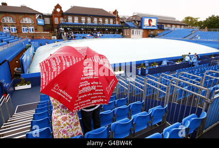 Tennis - AEGON Championships 2011 - Tag fünf - The Queen's Club. Die Zuschauer schützen sich unter Regenschirmen, während am fünften Tag der AEGON Championships im Queen's Club, London, der Regen aufhört zu spielen. Stockfoto