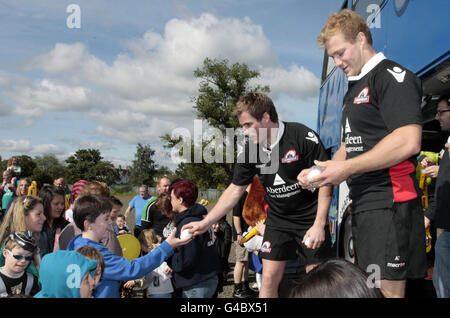 Phil Godman und Ross Rennie in Edinburgh geben Rugby-Bälle an einige der Kinder, die sich im Murrayfield-Stadion versammelt haben, um am 65. Ausflug der Taxifahrer in Edinburgh teilzunehmen. Stockfoto