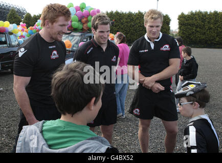 Die Rugby-Spieler Roddy Grant, Phil Godman und Ross Rennie aus Edinburgh sprechen mit einigen der Kinder, die sich im Murrayfield-Stadion versammelten, um am 65. Kinderausflug des Taxihandels in Edinburgh teilzunehmen. Stockfoto