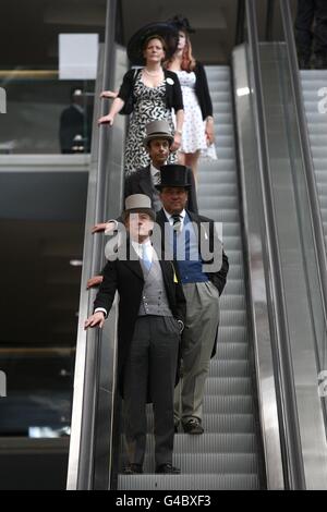 Gut gekleidete Rennfahrer machen sich am ersten Tag des Royal Ascot Meeting 2011 auf die Rolltreppe. Stockfoto