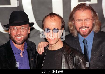 Die Bee Gess (von links) Maurice, Robin und Barry Gibb posieren für die Medien während einer Fotoaufnahme im Londoner Cafe Royal, wo sie 31 Jahre nach ihrem ersten Hit Pläne für eine gemütliche Welttournee vorstellten. 27/9/99 mit einer Sammlung von Briefmarken geehrt werden, die von der Insel ihrer Geburt ausgestellt werden, wo ihre Mutter einmal ein Postamt betrieben. I ve Gotta Get A Message to You ist einer der weltweiten Hits, die auf dem Briefmarkensatz der Isle of man, der am 12. Oktober erscheint, gefeiert werden. Bis auf den jüngsten musikalischen Bruder Andy wurden alle auf der Isle of man geboren, und der älteste Bruder Barry war neun Jahre alt Stockfoto