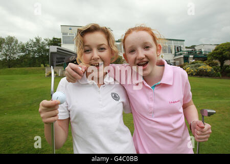 Zoe Henderson (links) und Alice Taylor, die junge Mitglieder des Holywood Golf Club in Co. Down, Nordirland, sind, feiern Rory McIlroys Sieg bei den US Open auf dem 18. Green seines Heimatclubs. Stockfoto