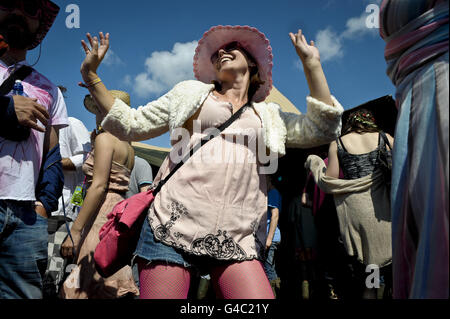 Nachtschwärmer tanzen beim Glastonbury Musikfestival auf der Worthy Farm, Pilton, Somerset, während die Sonne aufgeht. Stockfoto