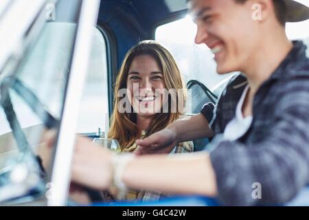 -MODELL VERÖFFENTLICHT. Junges Paar in einem Auto, lachen. Stockfoto
