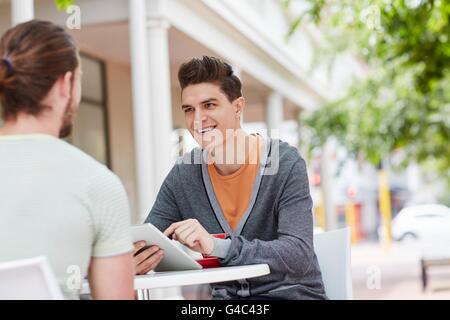 -MODELL VERÖFFENTLICHT. Zwei junge männliche Freunde mit digital-Tablette. Stockfoto