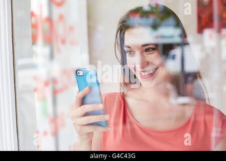 -MODELL VERÖFFENTLICHT. Junge Frau mit Smartphone. Stockfoto