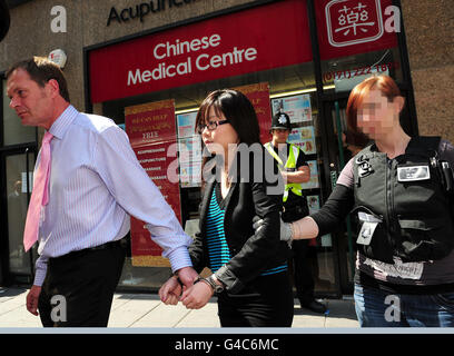 GESICHT VOM BILDTISCH VERDECKT AUF ANTRAG DER britischen GRENZBEHÖRDE WIRD EINE Frau vom chinesischen medizinischen Zentrum in Newcastle von Beamten der Polizei und der britischen Grenzbehörde weggeführt, wo sie wegen des Verdachts des Menschenhandels auf dem Gelände verhaftet wurde. Stockfoto