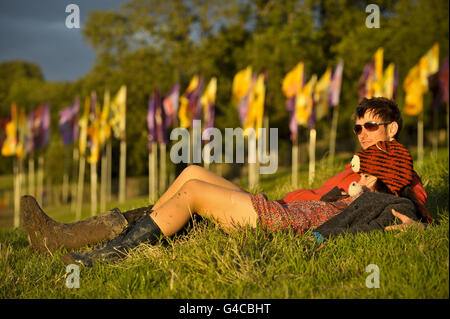 Nachtschwärmer entspannen sich und beobachten den Sonnenuntergang, während der Tag zu Ende geht und die Menschen sich auf die Abendfeiern beim Glastonbury Festival vorbereiten. DRÜCKEN SIE VERBANDSFOTO. Bilddatum: Mittwoch, 22. Juni 2011. Siehe PA Story SHOWBIZ Glastonbury. Bildnachweis sollte lauten: Ben Birchall/PA Wire Stockfoto