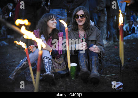 Nachtschwärmer können sich während der abendlichen Feierlichkeiten beim Glastonbury Festival am Steinkreis entspannen. Stockfoto